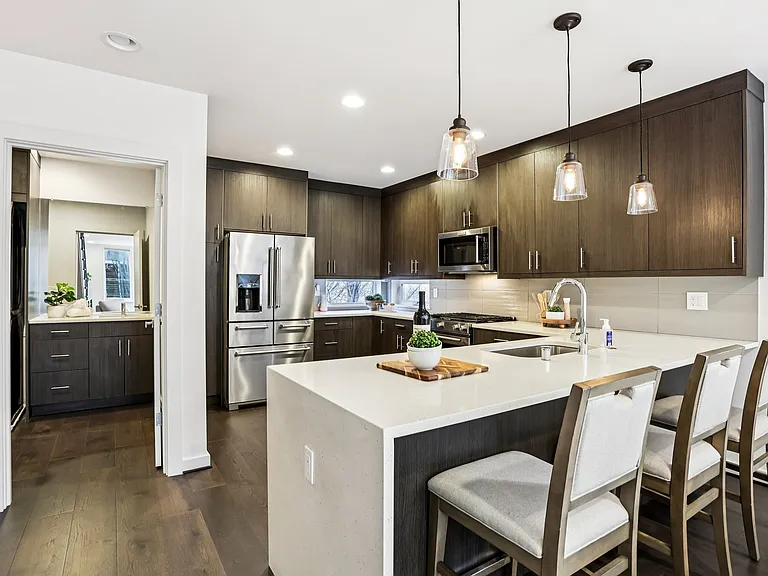 Chef's kitchen with large island, quartz waterfall counter, modern cabinets and high quality appliances.