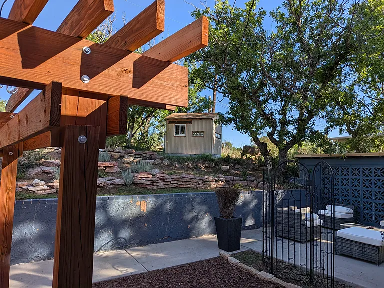 View of the Treehouse / Away space from the garden patio trellis with several seating areas