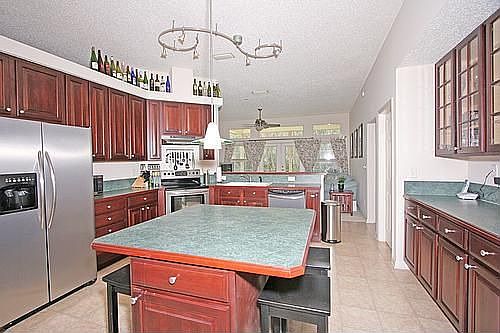 Large Kitchen w/eat-in island, stainless appliances, & tall cherry cabinets