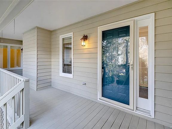 Another view of front porch also featuring a storm door