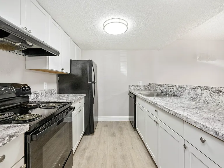 Modern kitchen with elegant white cabinetry, sleek countertops, and energy-efficient appliances.