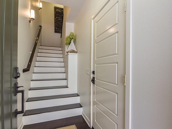 White door on the right connects entry way to garage. Stairs lead to main living space.