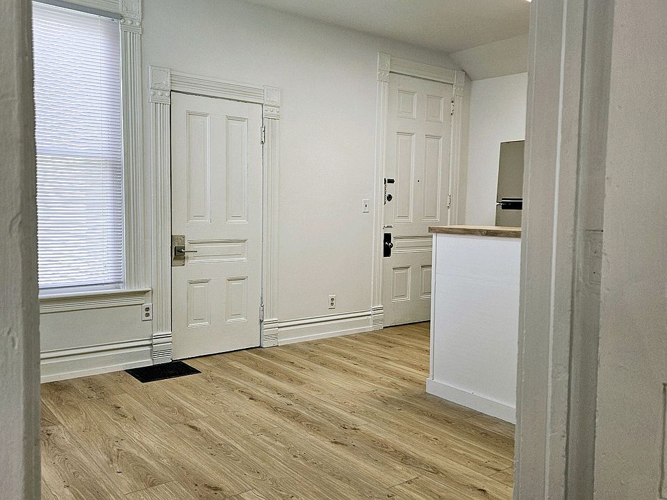 Entry door into apartment on right, closet door on left. Living room view from bedroom