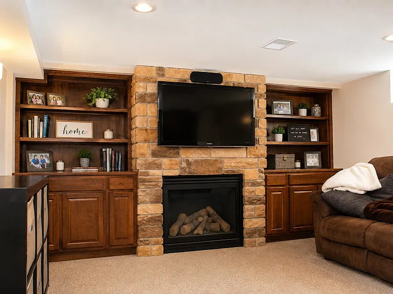 fully finished basement with fireplace, office, and walkout to attached garage