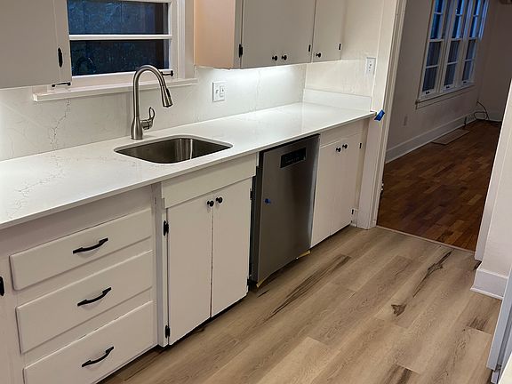 Renovated Kitchen features new dishwasher, sink, and quartz counters.