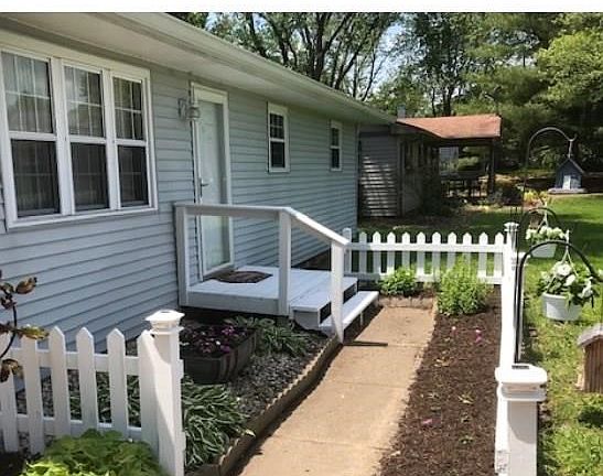 ANOTHER VIEW OF FRONT OF HOME WITH CUTE PICKET FENCE.