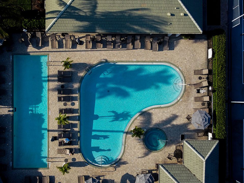 Birds-eye view of Clubhouse Pool complex with heated pool, lap pool, and hot tub. Right next to pickleball and tennis courts, along with fitness center.