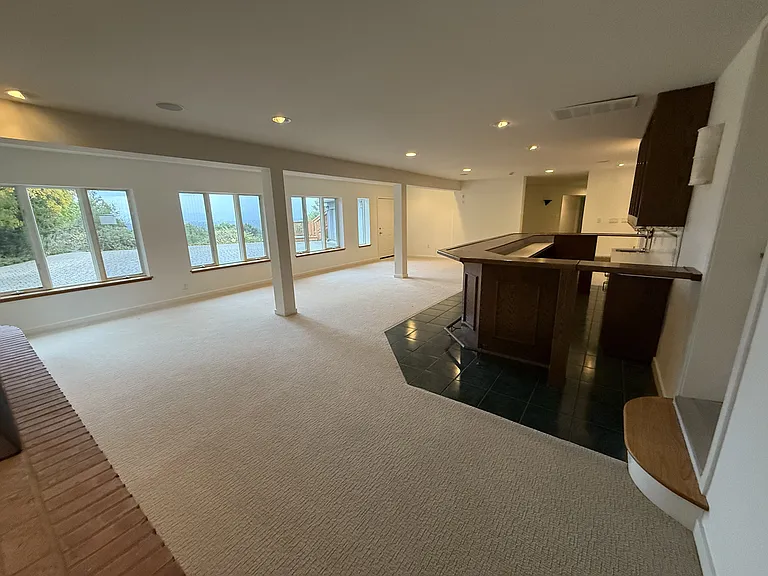 The large family room features a built-in bar featuring a mini refrigerator, sink and dishwasher.