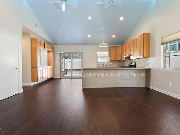 Kitchen, dining area with side buffet, breakfast bar, private back patio
