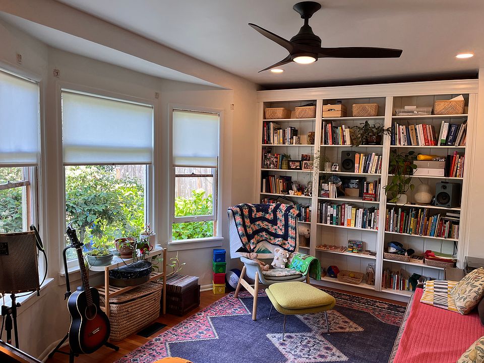 Living room with ceiling fan and bay window