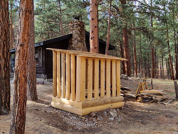 Firewood bin to the east holds approximately 1 cord of split stacked firewood. Area for gardening tools too, all covered.