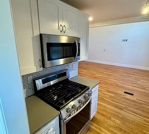 Galley Kitchen with stainless steel gas stove and microwave