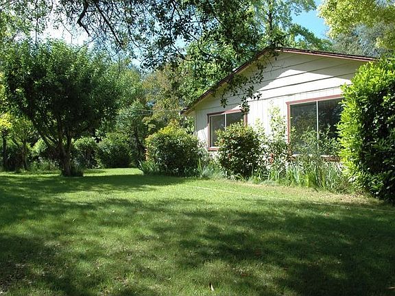 side, lawn, apple tree. Dining room windown is on left; liv rm wind on right