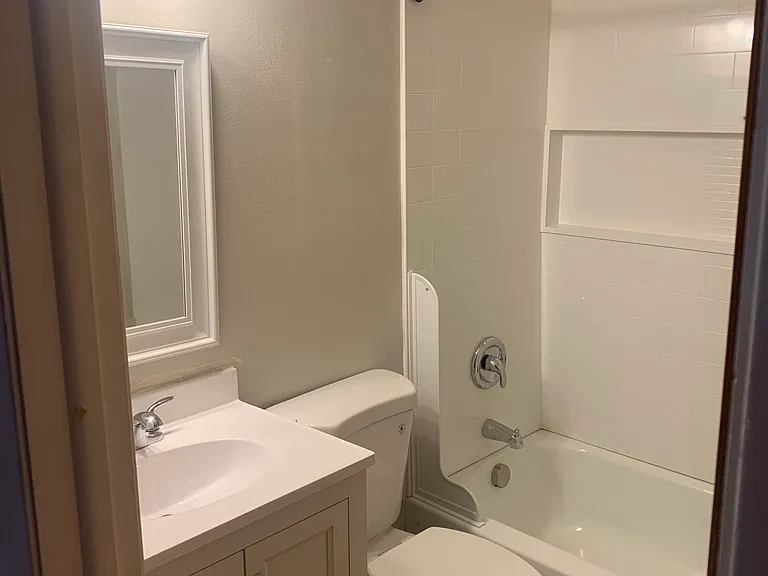 Bathroom new bathtub, sink, vanity, and toilet. Shower curtain included