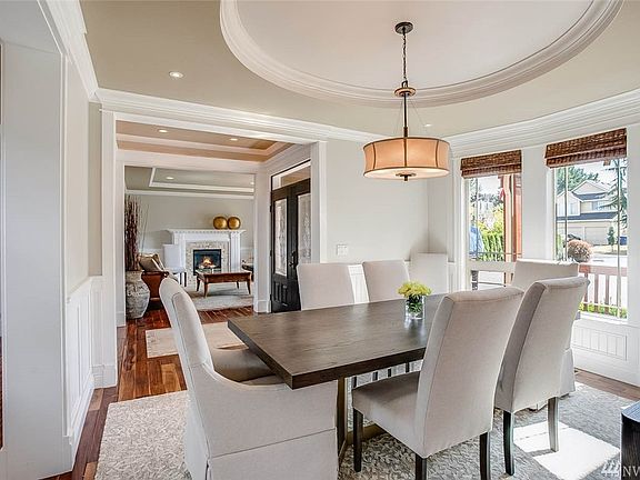 Open floor plan flows seamlessly from the Great room through to the Formal dining & Entry parlor - both adorned with coffered ceilings, wainscoting, crown molding, distressed hardwood floors and views through to the great room.