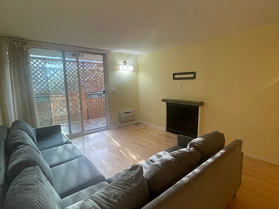 Living room including fireplace and wall AC unit