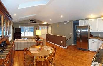 Living room with beautiful hardwood floors, vaulted ceiling,sky lights and open stairway to the lower level.