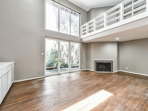 First floor features large formal living room.  Two story ceilings make the walls ideal for art. The two story windows offer lots of light and show off the garden patio. Also has wet bar and powder room.