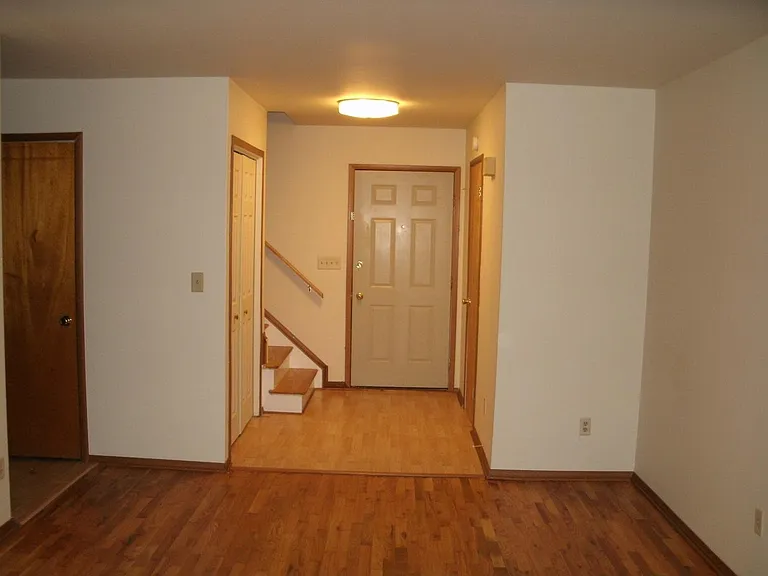Living Area with closet, Large window & Hardwood floor with access to main door and basement