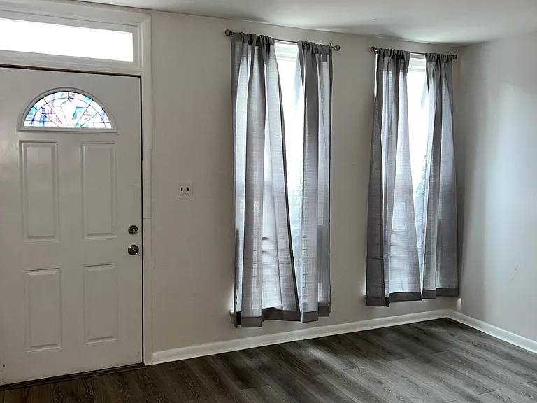 Walk into the living room with new flooring and ample sunlight