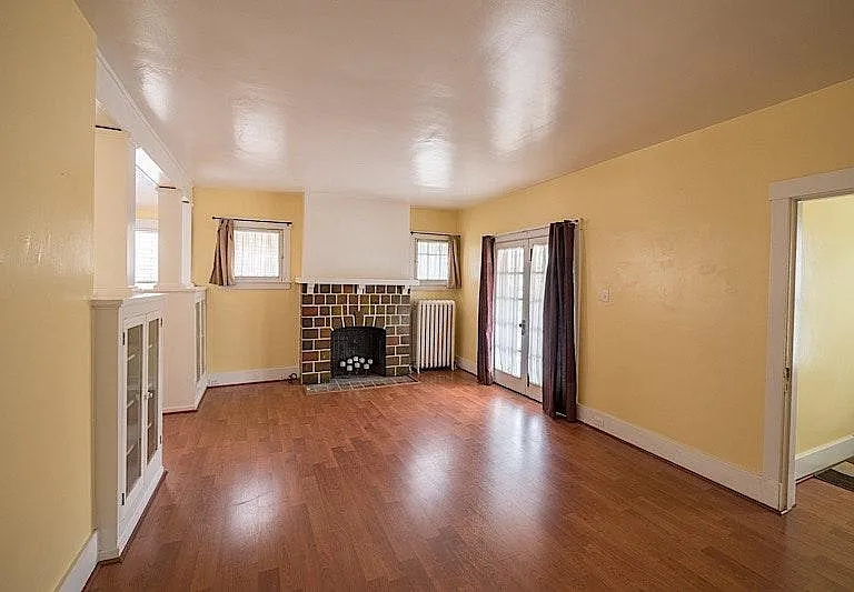 Large and Beautiful Living room with decorative Fire Place, Light and bright and hard wood floors.