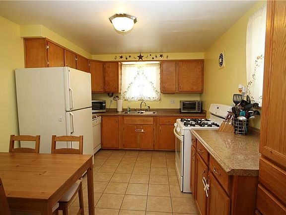 Updated & Spacious 14x10 Eat-in Kitchen w/ Ceramic Tile Floors, Newer Counter Tops & Plenty of Wood Cabinets all completed in Su