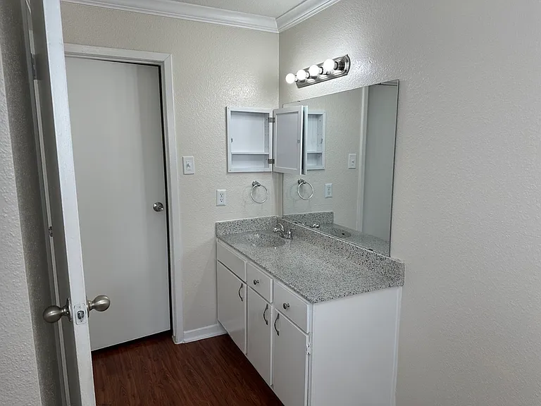 Modern bathroom with sleek countertop, spacious vanity, large mirror, and soft lighting fixtures. Modern bathroom with sleek countertop, spacious vanity, large mirror, and soft lighting fixtures.