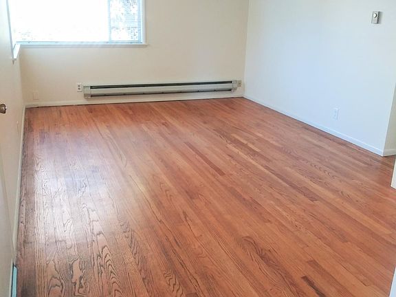 Bright and sunny large living room with beautiful hardwood floors