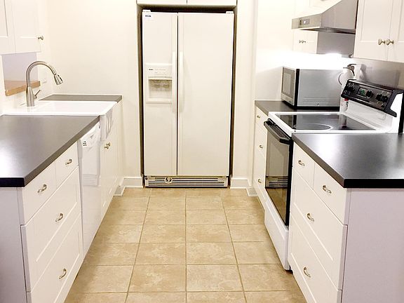 Modern kitchen with electric stove, dishwasher, disposal, microwave