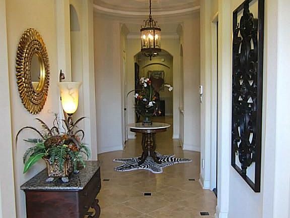 FRONT ENTRY SPACIOUS HALLWAY WITH ARCHWAYS PORCELAIN TILE FLOORING AND ART NICHE