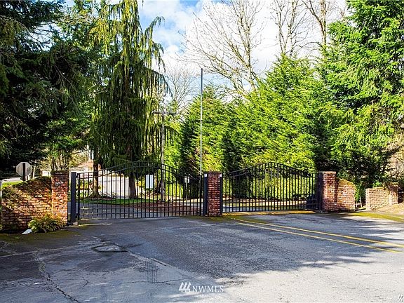 Gated neighborhood with lush green trees throughout. 
