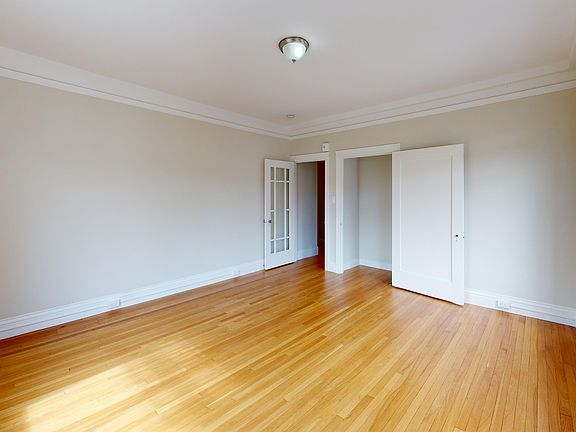 Bright bedroom with wood-like floor and a closet