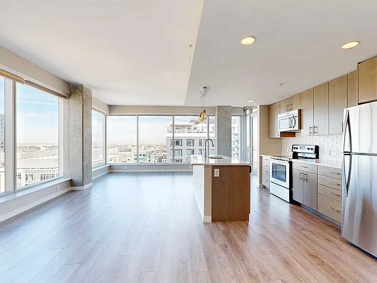 Apartment dining and living room with wood-style flooring.