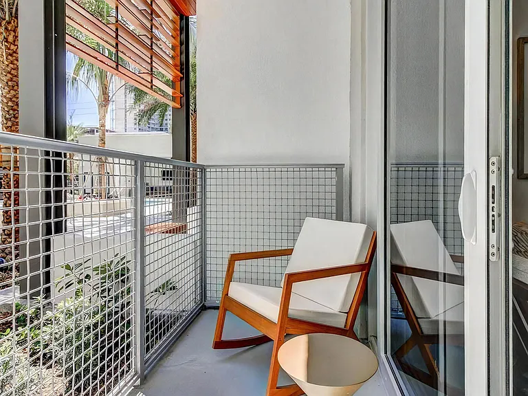 Outdoor Balcony Space With Simple Seating and Partial View of Community Landscaping