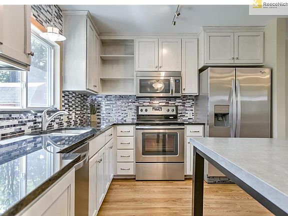 Granite counters, stainless steel Whirlpool appliances, custom hand stained weathered oak cabinets, rolling kitchen island