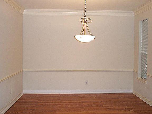 Formal dining room with double crown molding and wood grain laminate floor.