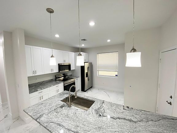 New granite countertops, cabinets, stainless steel appliances, and lighting features throughout. New appliances. New indoor washer and dryer (not in garage).