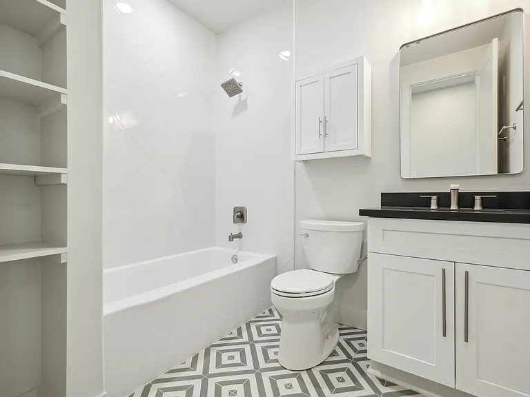 Second Bedroom/Hall Bathroom with custom tile, bathtub and linen shelf.