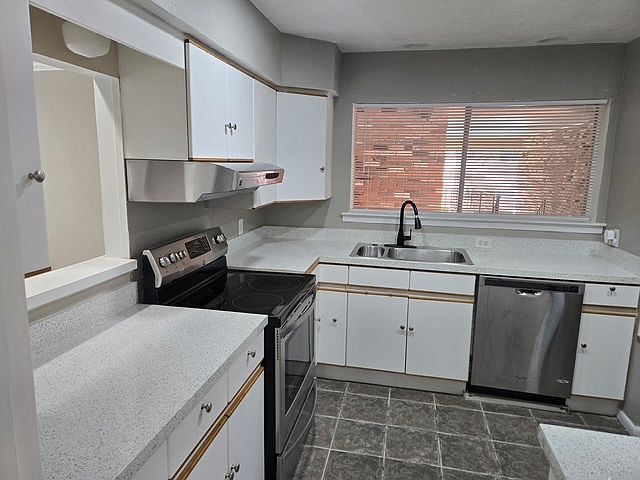 Stainless steel appliances in kitchen with natural light.