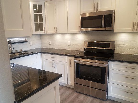 Dishwasher with new stainless refrigerator, stove and microwave and cabinets.