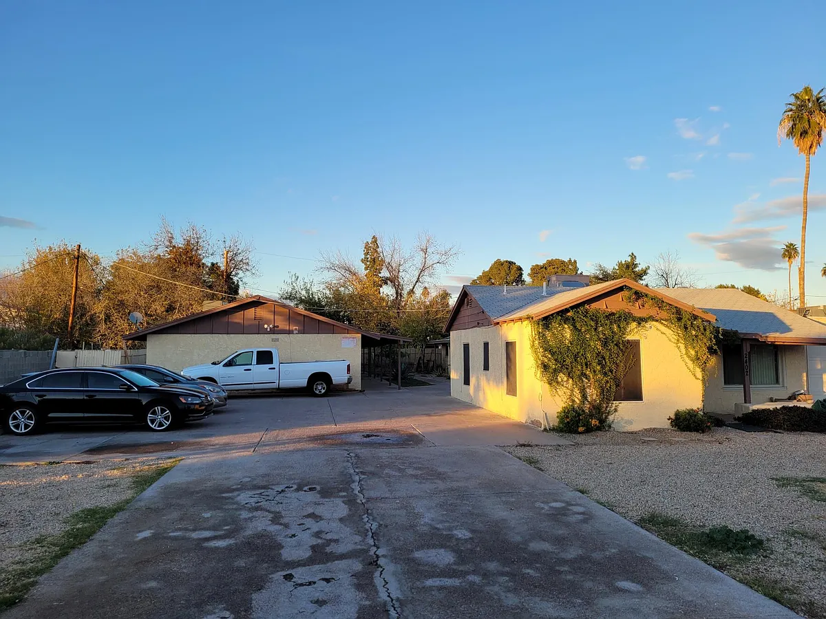 Property driveway and parking. The triplex and unit-2 are behind the white truck. - 2402 W Hayward Ave #2