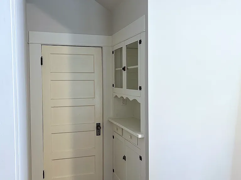 Door leading to walk in closet and laundry from living room. Original built in cabinet from 1914