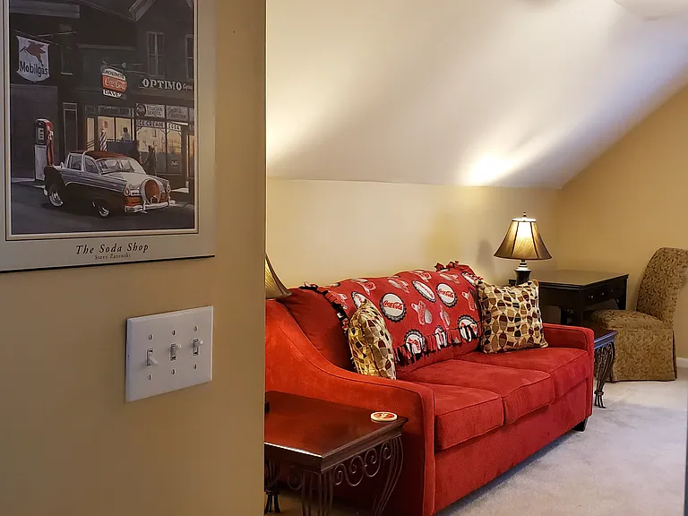 Bonus Room/Bedroom Combo with Couch, end tables and lamps, desk with damask upholstered chair.