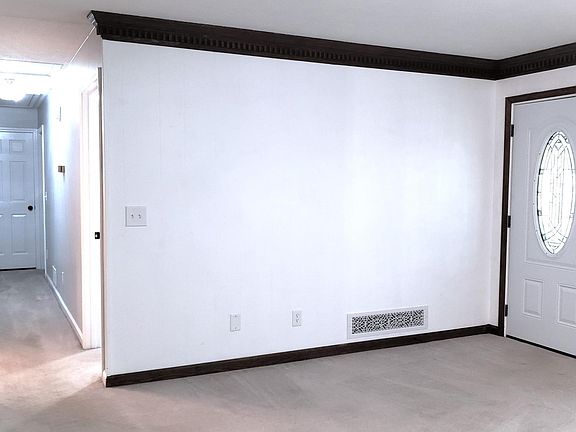 A large Living Room offers spaciousness for plenty of seating, with a scenic view of the front yard through double windows.