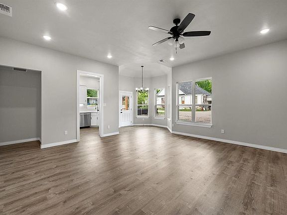 Spacious living area featuring wood-finish flooring, recessed lighting, and a ceiling fan