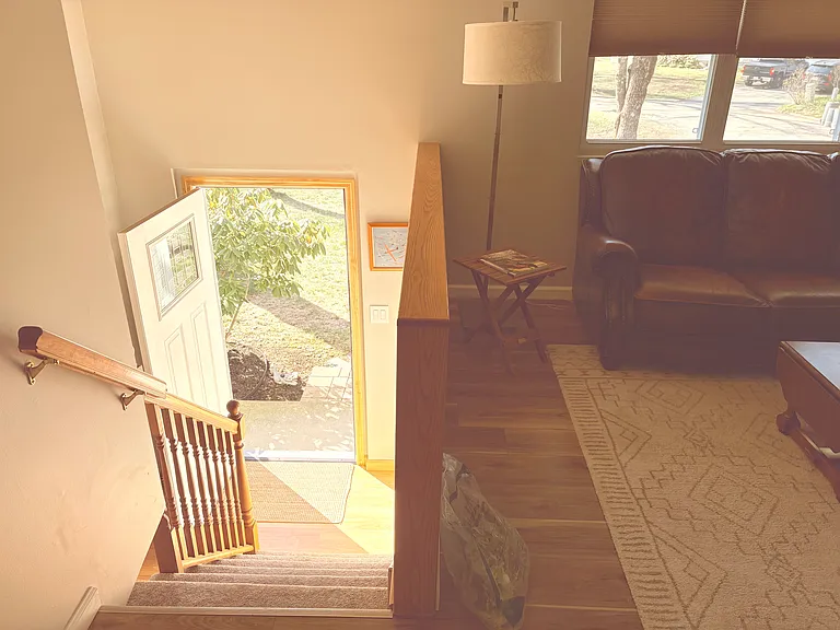 The front door leads to the front yard, and the living room offers two real leather couches and a newly installed 75'' smart TV, creating a comfortable space for relaxing and spending time together
