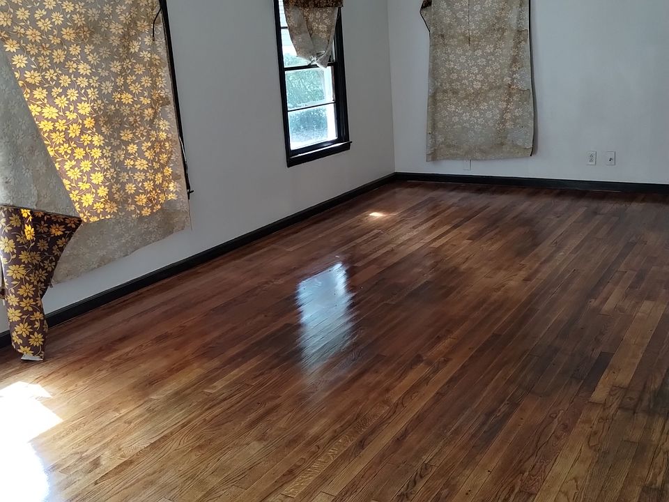 This is the open living room space that also includes the dining room. The fabric are just hung over the windows to keep it cooler in there while we're working on it. The ceiling fan blades were taken off to be cleaned after we had sanded the floors.