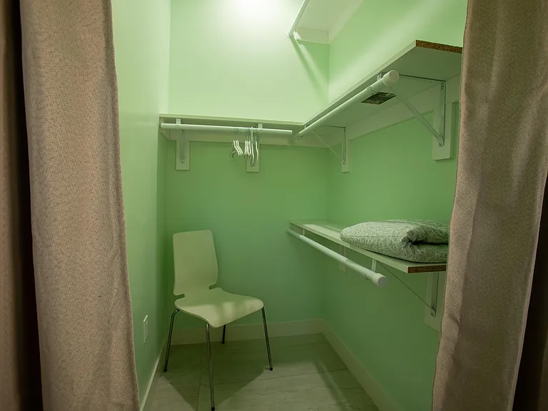 Walk in closet with a three tier closet rods for clothes and storage.