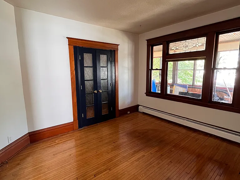 Living room. Hardwood floors, natural woodwork, big windows, baseboard heat through out. French doors open to the den/home office