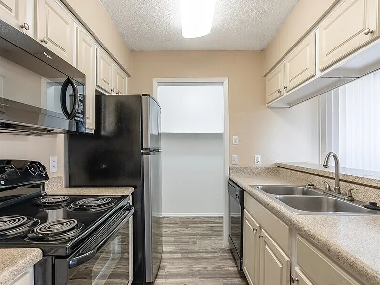 Renovated kitchen with sleek black appliances, ample cabinet space, and modern finishes.